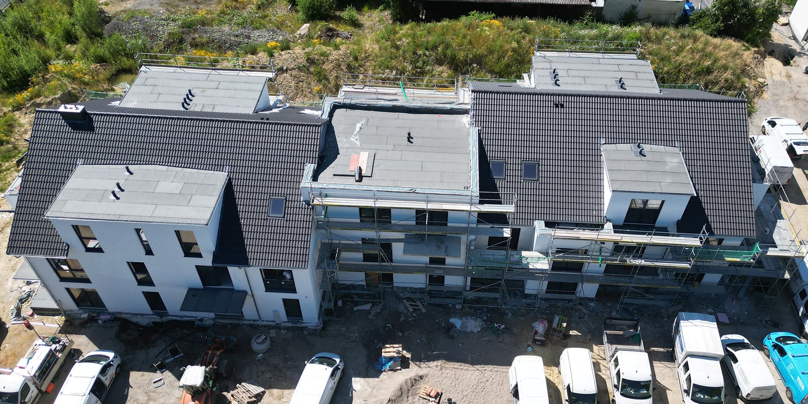 Luftaufnahme eines neu eingedeckten Dachs auf einem Mehrfamilienhaus im Bau