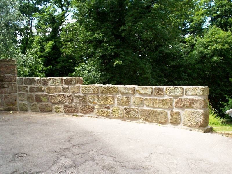 Instand gesetzte Natursteinmauer aus Sandstein mit neu verfugten Steinlagen