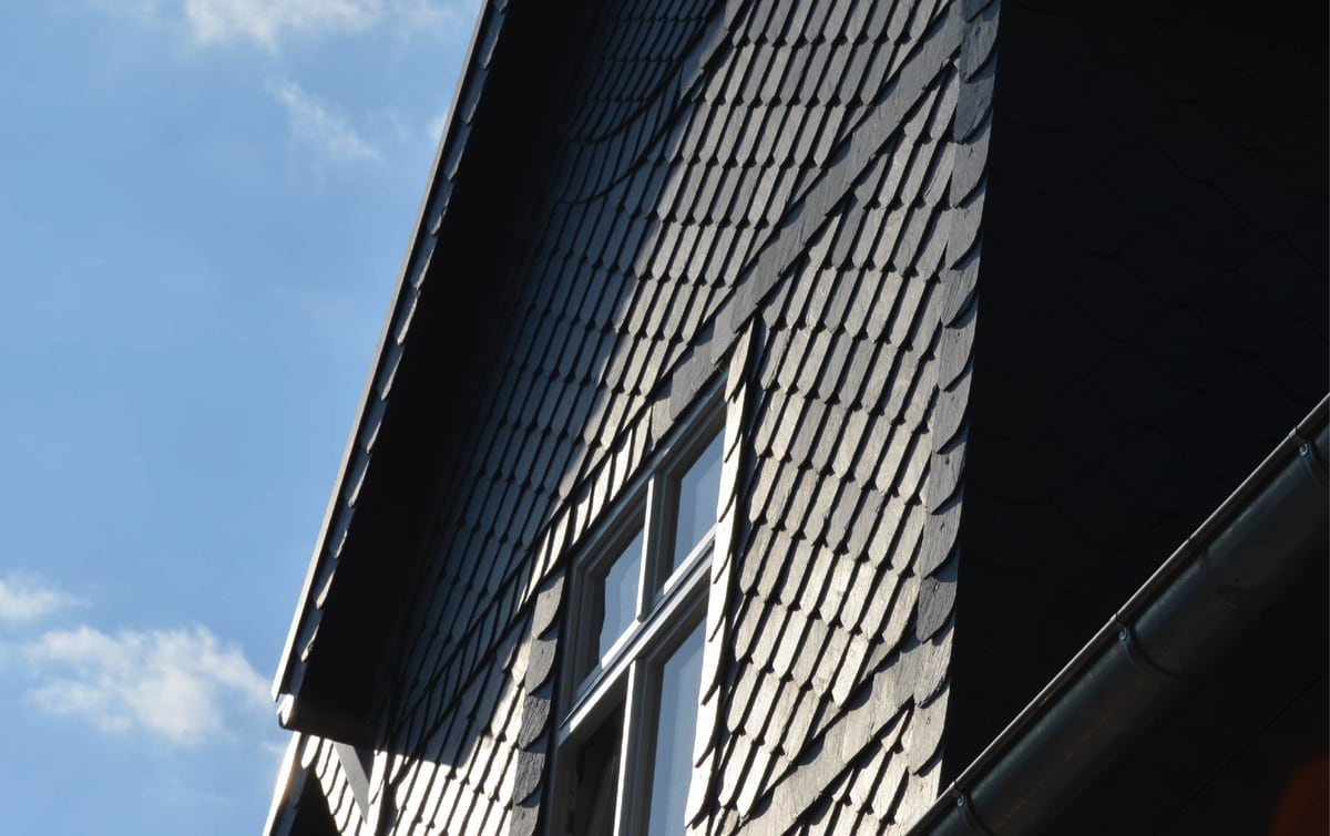 Fassade in Schieferschuppendeckung mit umlaufend eingedecktem Fensterausschnitt